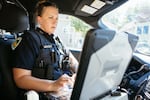 Officer Nicole Schmitgen works on her computer during her patrol in Madison, Wis.