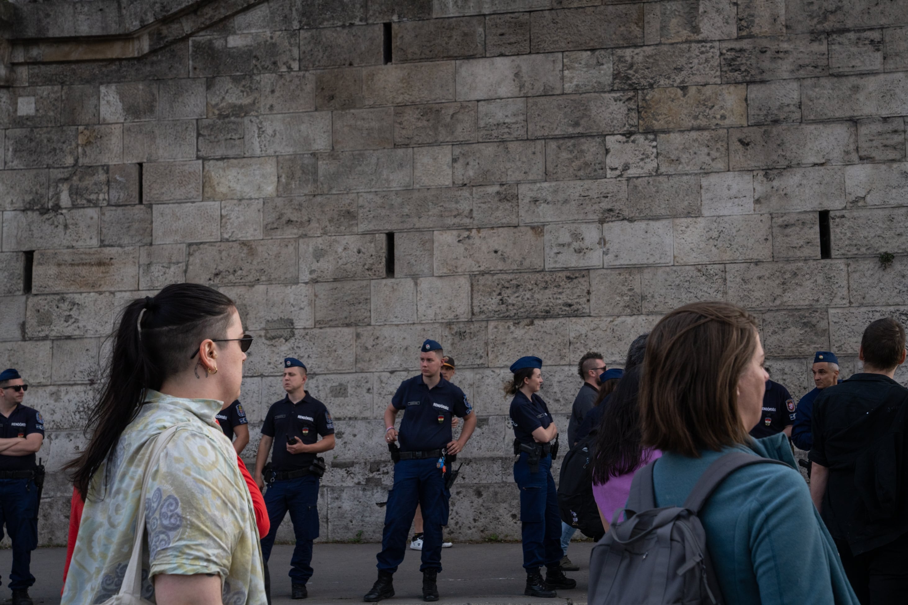 Police watch protestors who are demonstrating against Orbán and his policies on Tuesday.