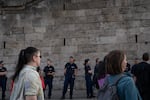 Police watch protestors who are demonstrating against Orban and his policies on Tuesday