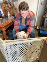 Class of 2025 student Austin plays with his dog in his parents' auto shop in Portland, Ore. on March 30, 2022. Last year, Austin would spend time with the family dogs after he was done with his virtual classes. He attended David Douglas Online Academy last year, an online-only program.