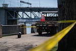 Caution tape and a city vehicle block off the scene of the car crash into the Willamette River in Portland, Ore., on April 6, 2026.
