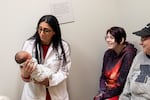 Dr. Mona Hanna-Attisha holds newborn baby Rowan, who was in for a wellness checkup with his 19-year-old mom, Hailey Toporek, and her mother, Heather Toporek, at the Hurley Children's Clinic in Flint.