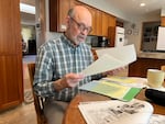 Bob Earnest sifts through letters and documents at his house in Portland's Hazelwood neighborhood on Feb. 11, 2025. Earnest has spent over two years asking the city to repair a light post in his neighborhood.