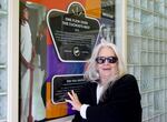 Eugene filmmaker Katherine Wilson poses in front of an Oregon Film Trail sign, featuring "One Flew Over the Cuckoo's Nest," at the Oregon State Hospital Museum of Mental Health in Salem, Ore., on April 5, 2023.