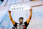 FILE - In this Monday, July 20, 2020, file photo, Romeo Ceasar holds a sign during a Black Lives Matter protest in Portland, Ore. Many Black protesters say the large crowds in response to the deployment of federal agents to the city have helped focus attention on their demonstrations against inequality and racism.