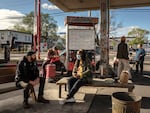 Marcia Howard, seated at center, speaks with another community member at George Floyd Square. Activists say they have gathered here every morning for the last five years.