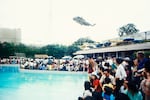 Evacuees inside the US Embassy surround the swimming pool as helicopter rescues stranded civilians trying to escape North Vietnamese troops about to capture Saigon (Photo by nik wheeler/Corbis via Getty Images)
