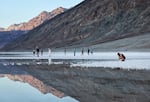 Visitors gather at the sprawling temporary lake at Badwater Basin salt flats at the recently reopened Death Valley National Park.