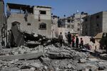 Palestinians look at a house targeted by an Israeli army strike in Khan Younis, Gaza Strip, Saturday, May 3, 2025.