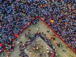 A century-old wrestling competition in Chittagong, Bangladesh, known as Abdul Jabbar's Boli Kheladraws thousands of spectators annually. In this picture from April 24, 2023, two wrestlers go at it on a sandy stage in front of a street audience.