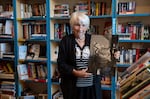 Joyce FitzSimmons, owner of The Book Peddler, poses with a portrait of Huxley that she keeps in the shop. The book shop is one of Huxley's favorite places to visit.