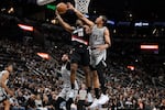Portland Trail Blazers guard Scoot Henderson (00) is fouled by San Antonio Spurs forward Carter Bryant during the first half of an NBA basketball game, Wednesday, April 8, 2026, in San Antonio.