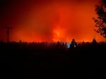 The sky glows red as the Two Four Two Fire burns in the distance in this image taken overnight Sept. 7-8, 2020 outside Chiloquin, Ore.