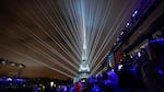 A laser show flashes past the Eiffel Tower in Paris, France, during the opening ceremony of the 2024 Summer Olympics, Friday, July 26, 2024.