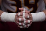 Central Catholic player Jack Bennison (39) rests his taped up hands before the start of the game. The Central Catholic Rams played the Lake Oswego Lakers at Hillsboro Stadium in Hillsboro, Oregon, on Dec. 7, 2019. The Rams defeated the Lakers 49-28.