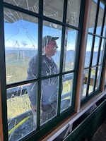 Volunteer leader Don Allen inspects the windows of the High Rock Lookout after vandalism in June. Volunteers had spent years restoring these windows.