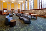 In this February 2024 photo, provided by the Multnomah County Library, one of the refurbished spaces in the 1913 building is pictured, with comfortable furniture and shelved books and reference material.