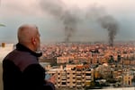 A man looks as smoke rise from Israeli airstrikes in Dahiyeh, Beirut, Lebanon, early on Sunday.