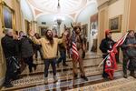 In this Wednesday, Jan. 6, 2021 file photo supporters of President Donald Trump are confronted by U.S. Capitol Police officers outside the Senate Chamber inside the Capitol in Washington. Jacob Anthony Chansley, the Arizona man with the painted face and wearing a horned, fur hat, was taken into custody Saturday, Jan. 9, 2021 and charged with counts that include violent entry and disorderly conduct on Capitol grounds.
