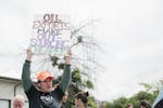 A protester hoists a sign at a 2016 protest against oil trains in Vancouver, Washington.