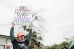 A protester hoists a sign at a 2016 protest against oil trains in Vancouver, Washington.