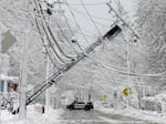 In this 2018 file photo, a police vehicle blocks a road near downed power lines in Natick, Mass. To prepare for a potential power outage, make sure you have backup power sources and an emergency plan in the event of a prolonged blackout, say experts.