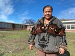 Rosanna Jackson, an enrolled member of the Confederated Tribes of the Warm Springs, is heading up the effort to start the first ever suicide prevention helpline run by and for Native youth. Jackson stands in front of her old elementary school on the Warm Springs reservation on Feb. 7, 2024.