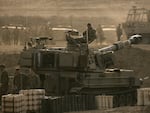 Israeli soldiers sit on an artillery unit near the Israeli border with the Gaza Strip, in Netivot, Israel, Oct. 22, 2023.