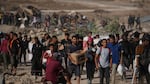 Palestinians carry food packages near a distribution site operated by the U.S.-backed Gaza Humanitarian Foundation in Khan Younis, southern Gaza Strip, Thursday. (AP Photo/Abdel Kareem Hana)
