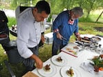 Chefs Hamid Serdani, left and Rick Browne prepare dishes using feral pig, dandelion greens and blackberries.