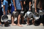 A large number of Palestinians, including children, gather in order to obtain food, on Aug. 25 in Deir al-Balah, Gaza. Due to the deepening hunger crisis, Palestinians facing difficulties in accessing food were provided with hot meals at the Nuseirat Refugee Camp in central Gaza.
