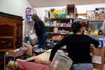 Mutual aid volunteers Annie, left, and Jasmine organize food and home staple items, most of which were donated or bought with donation funds the group gathered, for people in hiding due to U.S. Immigration and Customs Enforcement raids at a volunteer’s Hillsboro, Ore., home on Dec. 5, 2025.