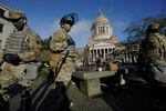 Members of the Washington National Guard stand at a sundial near the Legislative Building, Sunday, Jan. 10, 2021, at the Capitol in Olympia, Wash. Governors in some states have called out the National Guard, declared states of emergency and closed their capitols over concerns about potentially violent protests. Though details remain murky, demonstrations are expected at state capitols beginning Sunday and leading up to President-elect Joe Biden's inauguration on Wednesday.