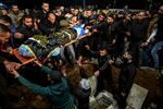 Mourners lower the flag-draped body to the grave of one of three men killed earlier in an Israeli air strike that targeted a car in Jenin in the occupied West Bank on March 20. (Photo by RONALDO SCHEMIDT / AFP) (Photo by RONALDO SCHEMIDT/AFP via Getty Images)