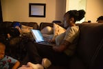 Monet Carter-Mixon sits with her sons while reading pre-law coursework at her University Park apartment in Seattle. Her brother's death has highlighted shortcomings in police reform efforts.