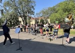 SOU graduate student Martin Bichinsky directs music and choir students at a protest before the board of trustees meeting on May 8, 2026. Students played instruments and sang to demonstrate support for the music department, one of the programs identified for possible elimination.