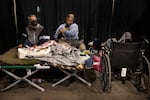 Don and Carrie Rascal from Phoenix rest on a cot with their dog at the evacuation center set up at the Jackson County Fairgrounds on Saturday, Sept. 12, 2020 in Central Point, Ore. They lost their home to the destructive wildfires devastating the region.