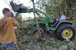 Retired Albany farmer, Loren Gerig, right, clears brambles away with the help of a team of hunters in August.