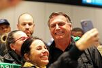 Brazilian former President Jair Bolsonaro poses for a photo with supporters after arriving at the international airport in Florianopolis, Santa Catarina state, Brazil, Friday, July 5, 2024. Brazilian police have indicted Bolsonaro for money laundering and criminal association in connection with undeclared diamonds the far-right leader received from Saudi Arabia during his time in office, according to a source with knowledge of the accusations.