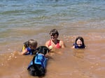 Lead Courageous Kids camp counselor Shelley Steward and support dog, Jack, swim with campers in Fall Creek Reservoir.