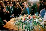 Mourners place flowers on AIDS author Randy Shilts' casket before leaving the Glide Memorial Church in San Francisco, Feb. 22, 1994. Twelve hundred friends and family members came to pay their last respects inside the church, with over 1,500 more outside in the streets.