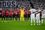 Players of Real Madrid and AC Milan observe a minute of silence for the victims of floods in Spain before the Champions League opening phase soccer match at the Santiago Bernabeu stadium in Madrid, Spain, Tuesday, Nov. 5, 2024. (AP Photo/Manu Fernandez)