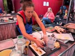 Baker Michelle Wald shapes a fortune cookie over the rim of the glass during the technical challenge of the Big Portland Bake Show in Portland, Ore. on June 27, 2026.