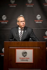 The OSU President F. King Alexander stands at a lectern bearing the name of the university he oversees.