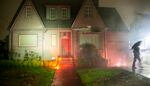 Protesters chant "Black lives matter" while throwing paint-filled balloons and watching flares burn at the home of Portland City Commissioner Dan Ryan, Nov. 5, 2020.