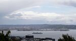 A Washington state ferry leaving Seattle passes under an arc of clouds in front of the Port of Seattle during the coronavirus pandemic, Thursday, April 30, 2020, as seen from Kerry Park. (AP Photo/Ted S. Warren)