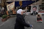 Shoes hanging in front of portraits of ousted Syrian President Bashar Assad in Damascus, Syria, Monday, Dec. 23, 2024.