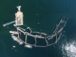 FILE - In this photo provided by the Washington State Department of Natural Resources, a crane and boats are anchored next to a collapsed "net pen" in Washington state on Aug. 28, 2017. This form of aquaculture is not presently practiced in Oregon, and now lawmakers are considering banning it in the state.