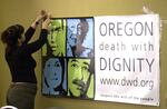 FILE - In this May 26, 2004, file photo, Linda Miles tapes up a banner in Portland, Ore., before it was announced that the 9th Circuit Court of Appeals upheld Oregon's Death with Dignity law. Oregon's Death with Dignity Act is now 20 years old. Voters approved the aid-in-dying proposal in 1994 and it then survived a repeal effort. The law that took effect Oct. 27, 1997 made Oregon the first state to make it legal for a doctor to prescribe a life-ending drug to a terminally ill patient of sound mind who makes the request.