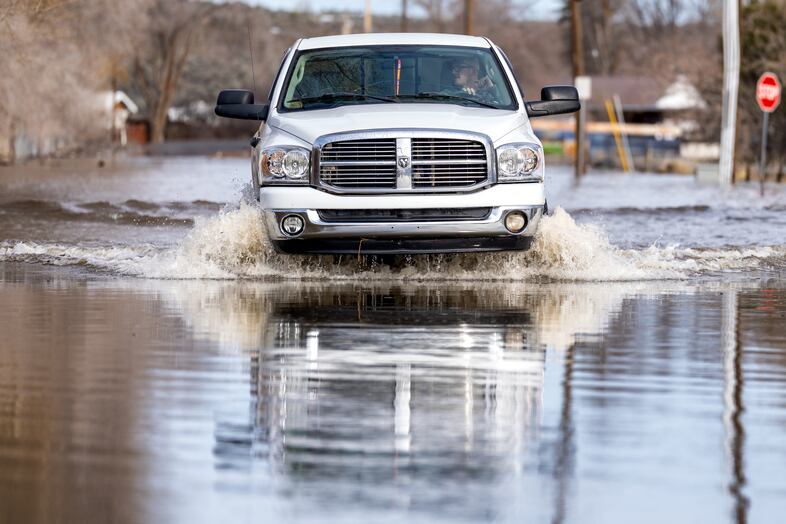 A vehicle drives through floodwaters on North Foley Drive in Burns, Ore., March 30, 2025. 